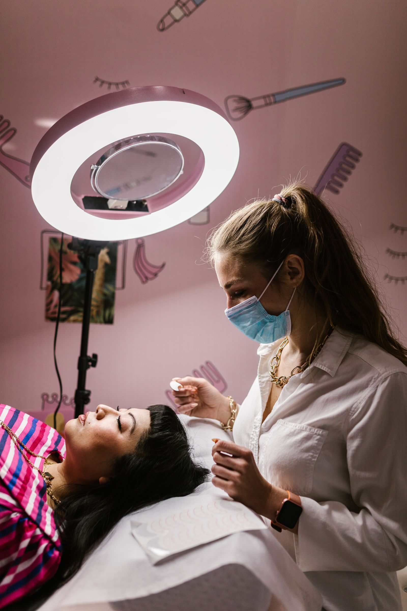 Mulher desfrutando de um tratamento facial relaxante em um moderno salão de spa, sob uma luz de anel brilhante.